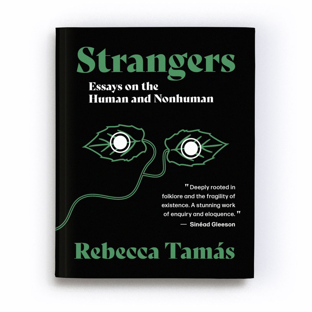 A render of the Charcoal Edition of the book ‘Strangers: Essays on the Human and Nonhuman’. In the centre of the cover is an abstract motif of two green leaves, joined by a stalk which winds from the centre to the bottom left of the cover. A white filled circle, outlined with a ring, overlays each leaf, giving the impression the leaves are a pair of eyes staring out at us from the cover. A quote by Sinéad Gleeson reads: 'Tamás’ essays are deeply rooted in folklore and the fragility of existence. A stunning work of enquiry and eloquence.' The text is a mixture of white and green in colour and is placed on a black background.