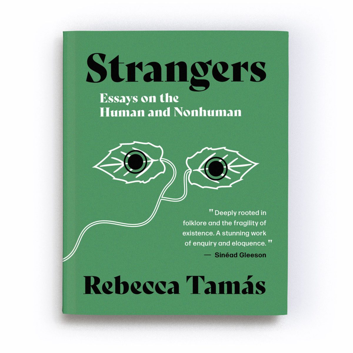 A render of the first edition of the book ‘Strangers: Essays on the Human and Nonhuman’. In the centre of the cover is an abstract motif of two white leaves, joined by a stalk, which winds from the centre to the bottom left of the cover. A black filled circle, outlined with a ring, overlays each leaf, giving the impression the leaves are a pair of eyes staring out at us from the cover. A quote by Sinéad Gleeson reads: 'Tamás’ essays are deeply rooted in folklore and the fragility of existence. A stunning work of enquiry and eloquence.' The text is a mixture of white and black in colour and is placed on an emerald green background.