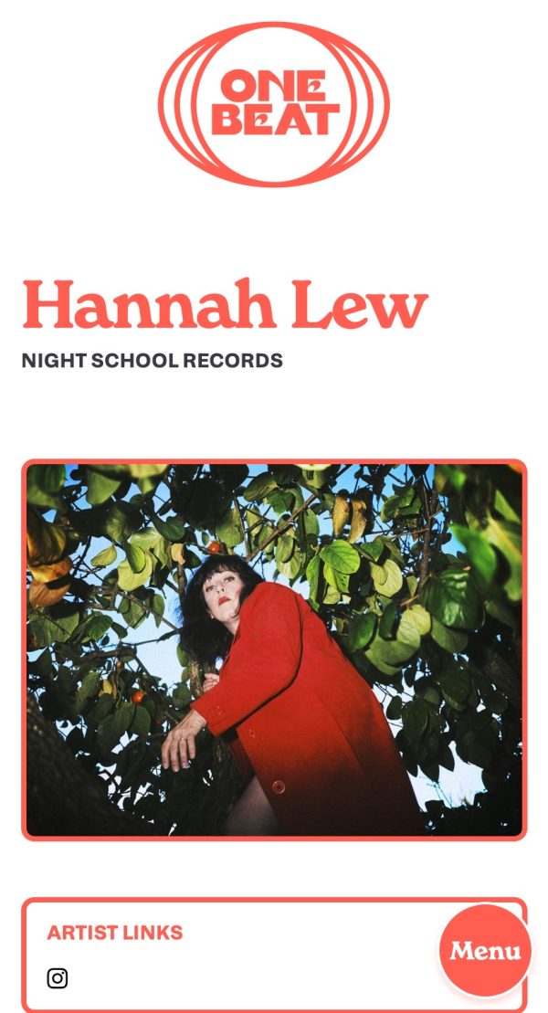 A page from the One Beat PR website, viewed on a mobile screen. In the top-centre is the site's logo, in a pastel red, which consists of an oval, globe-like or possibly drum-like shape within which is the text 'One Beat' in a thick, all-caps serif with a seventies slant. Underneath is the text 'Hannah Lew' in a large chunky, slightly seventies red serif font, sitting just above the words 'Night School Records' in a much smaller black bold uppercase sans-serif. Below is a photograph, taken from a low angle and looking up at a person standing below a tree, with blue sky peeking through the leaves. The person has dark brown hair, red lipstick, is wearing a red coat and stares defiantly into the camera, albeit with a slightly startled air, as if they have just been discovered up to no good.